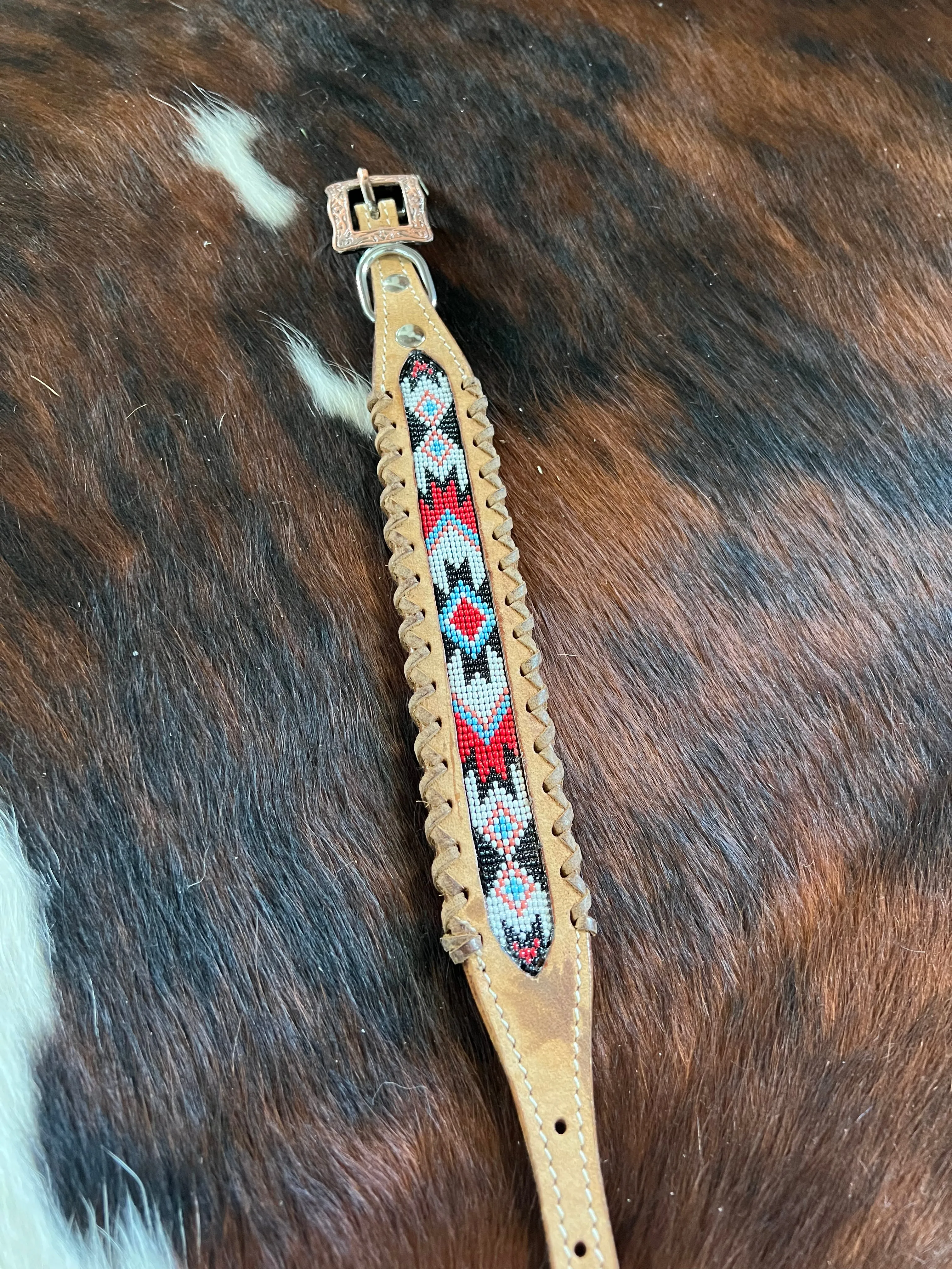 Genuine leather dog collar with red, white, and black navajo beaded inlay design, a leather wrapped edge